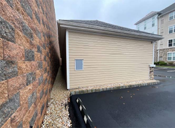 Gap between a parking structure wall and an adjacent building creating a concealment opportunity on a multifamily property
